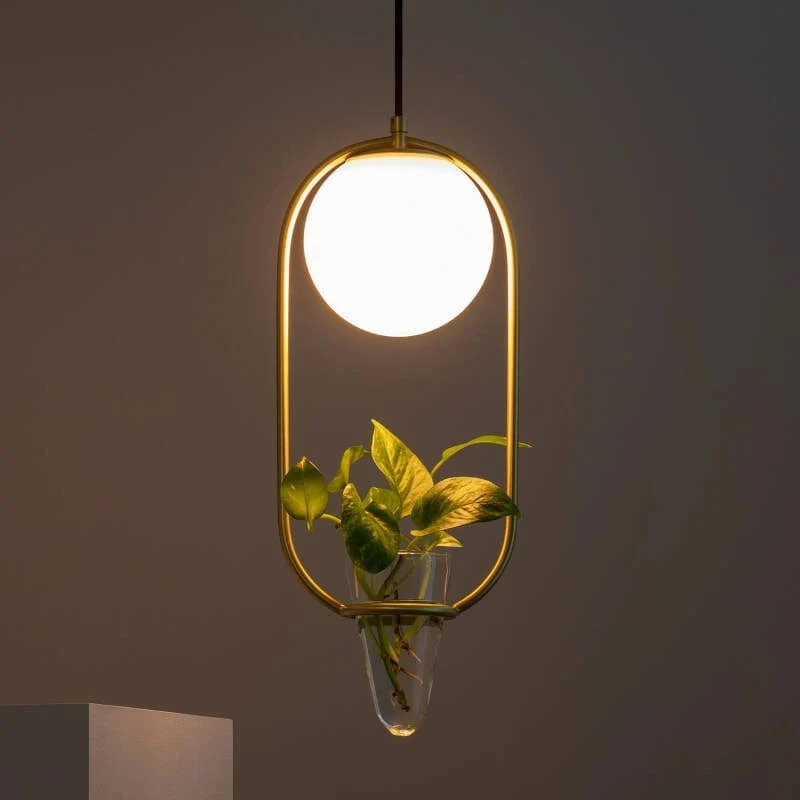 Suspension or et boule blanche avec fausse plante